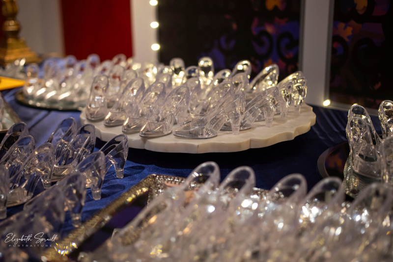 Numerous small glass slippers adorn a table as part of the fun and games that help benefit Vanessa Behan